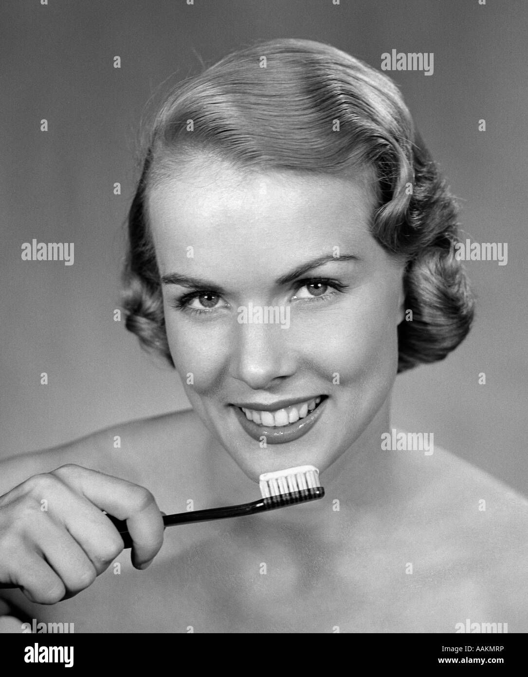 1950 SMILING WOMAN HOLDING BROSSE À DENTS Banque D'Images