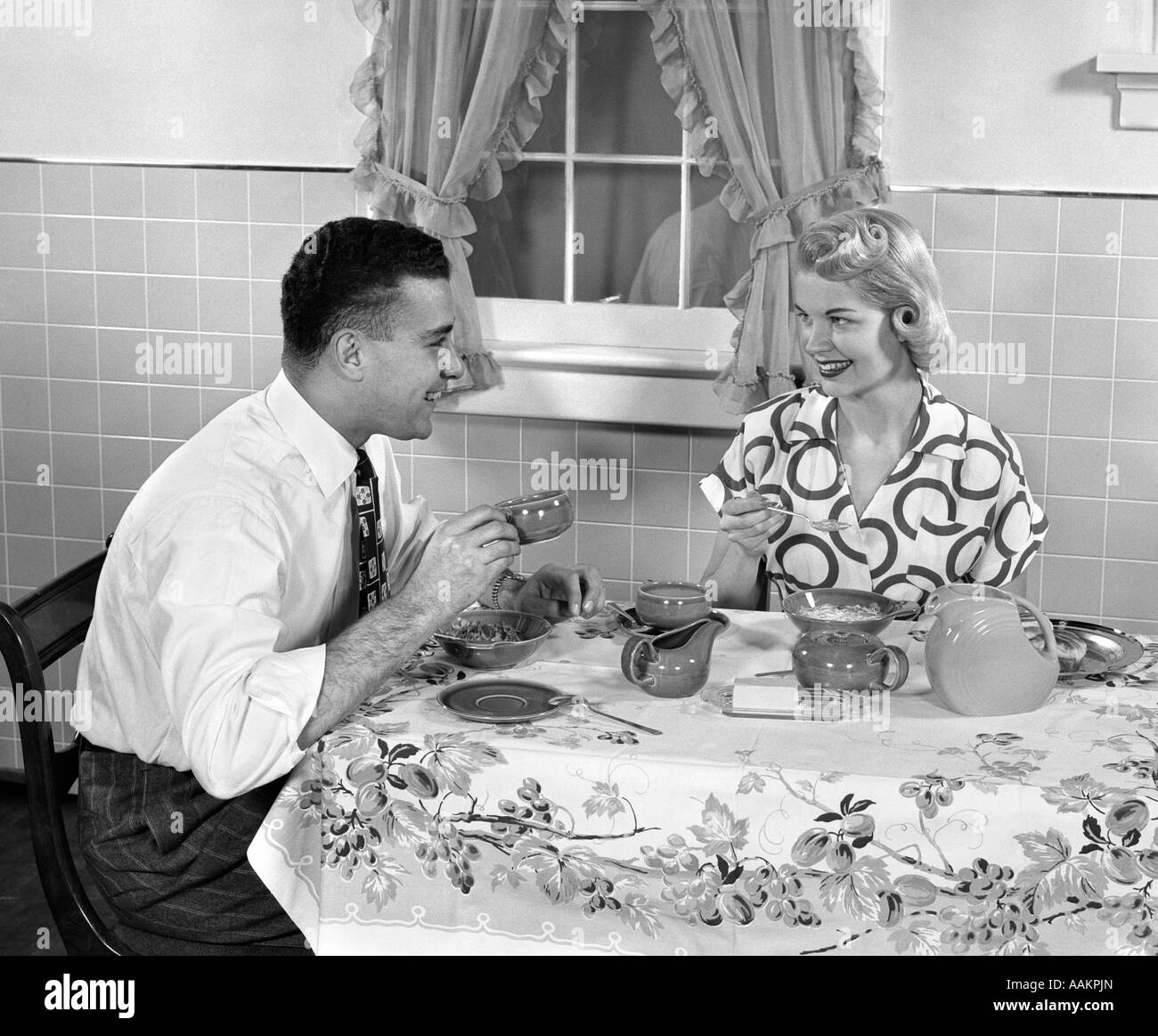 1950 MARI ET FEMME AU PETIT-DÉJEUNER, manger des céréales et boire du café Banque D'Images