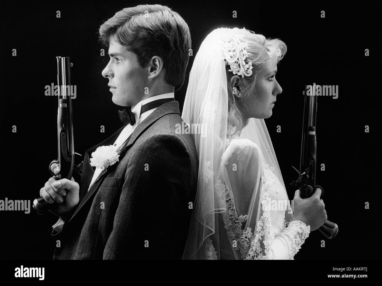 80 Bride and Groom STANDING BACK TO BACK HOLDING pistolets de duel Banque D'Images