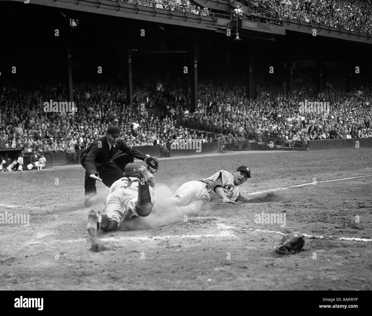 Années 1950, la ligue majeure de baseball professionnel RUNNER JEU GLISSANT DANS HOME BASE COMME JUGE-ARBITRE EN TOUTE SÉCURITÉ LES SIGNAUX Banque D'Images