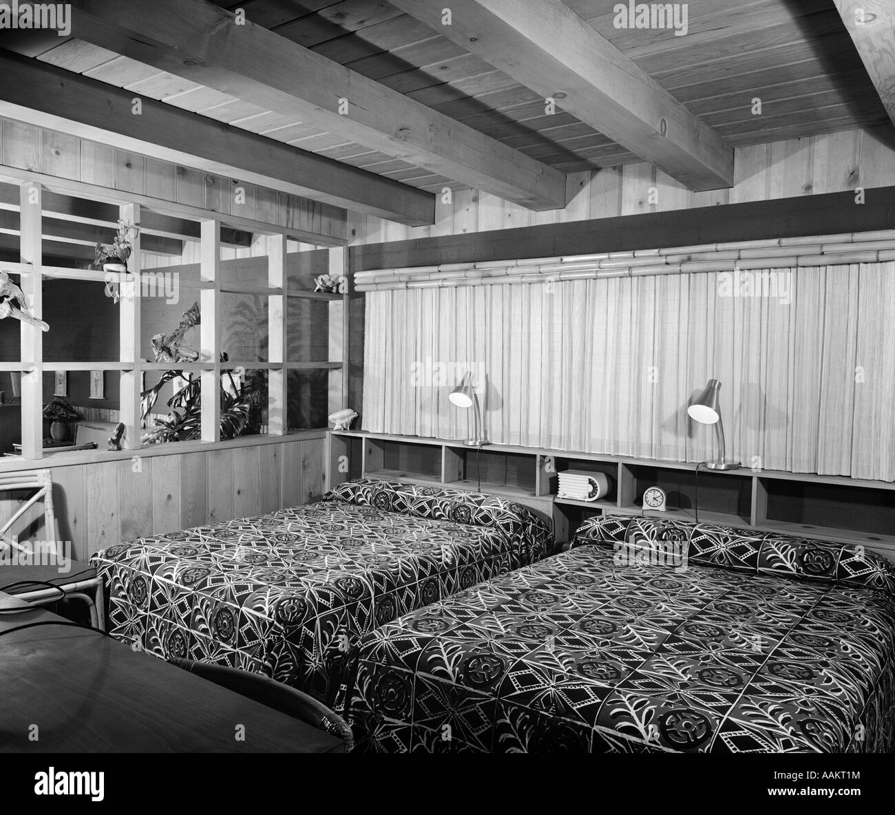 1950 MOTEL CHAMBRE AVEC 2 LITS DOUBLES PANNEAUX DE BOIS ET FENÊTRES À REGARDER SUR LE SALON Banque D'Images