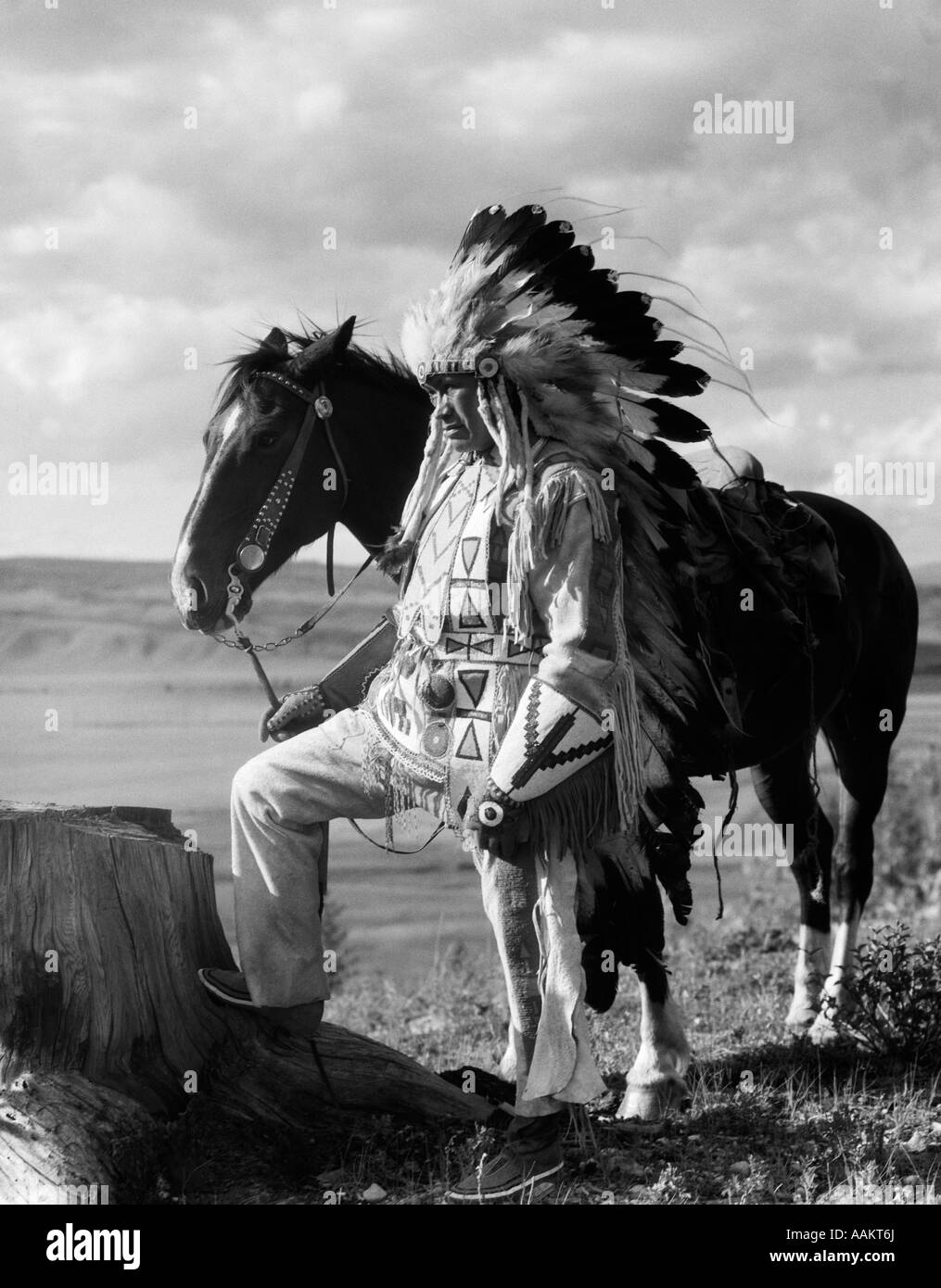 1930 PORTRAIT INDIEN SIOUX homme portant une coiffe de plumes DE CHEVAL RÊNES HOLDING Banque D'Images