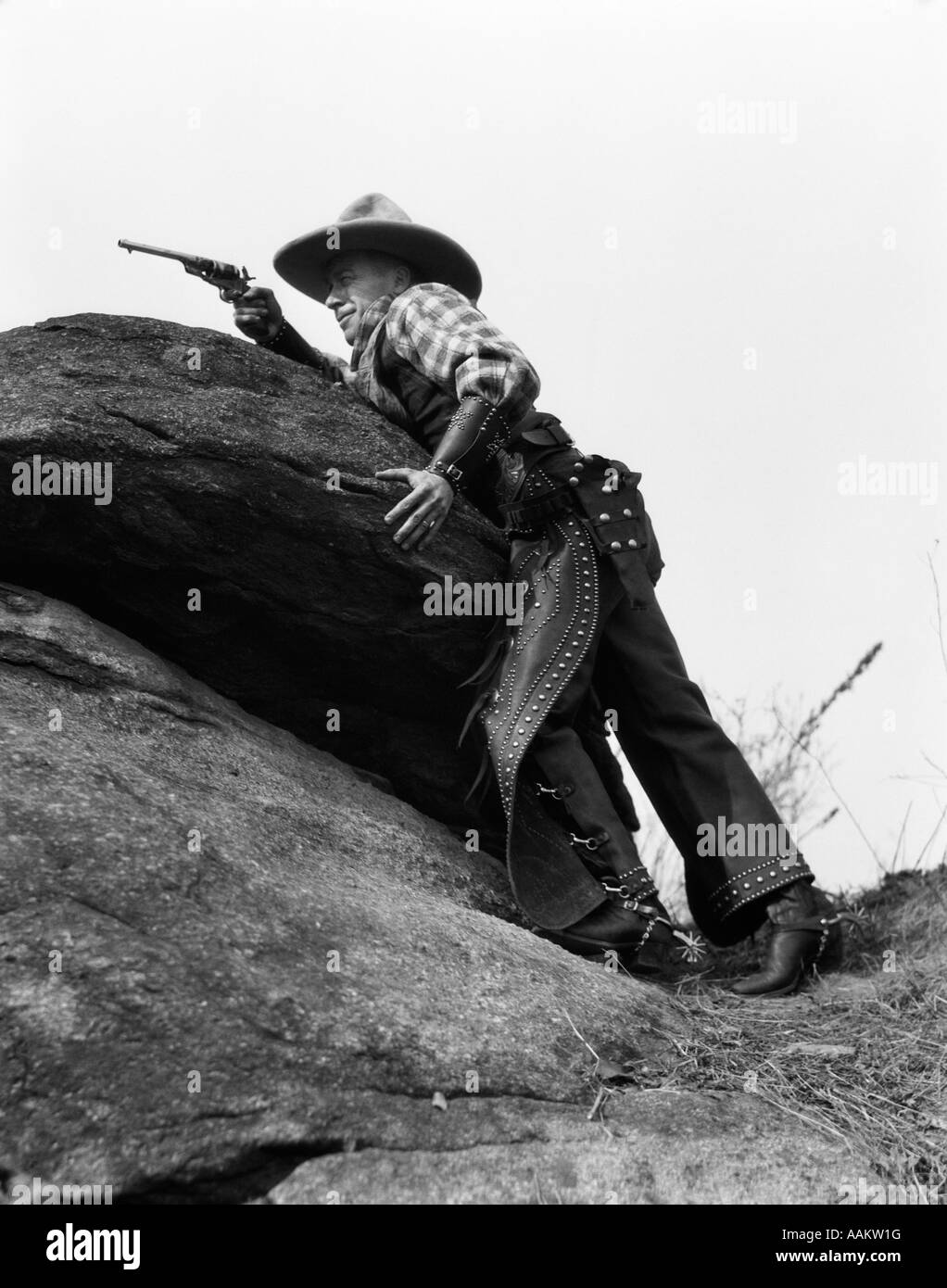 Années 1920 AU MILIEU DES ROCHERS COWBOY REVOLVER VISANT Banque D'Images