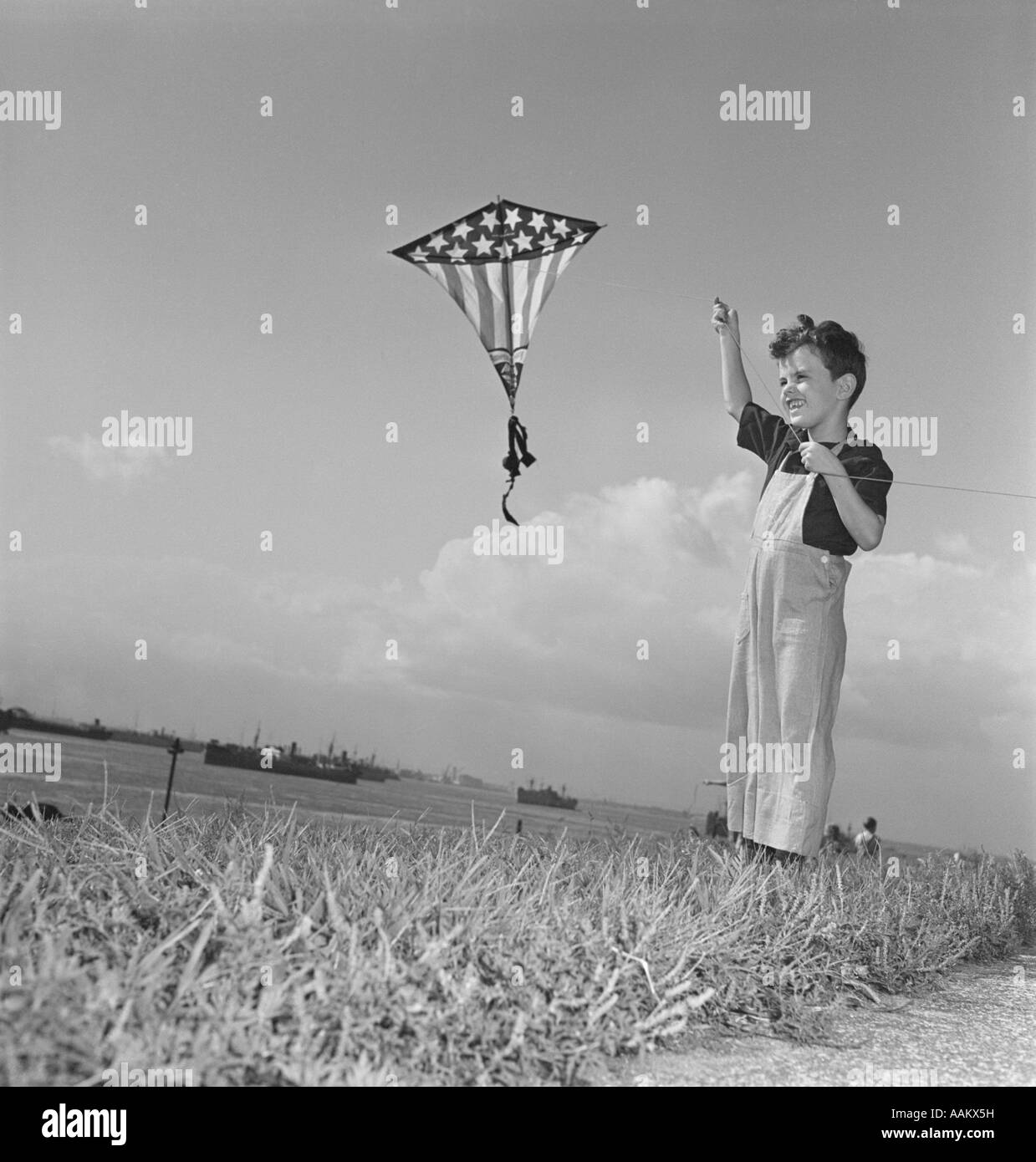 1940 SMILING BOY FLYING Stars and Stripes KITE Banque D'Images