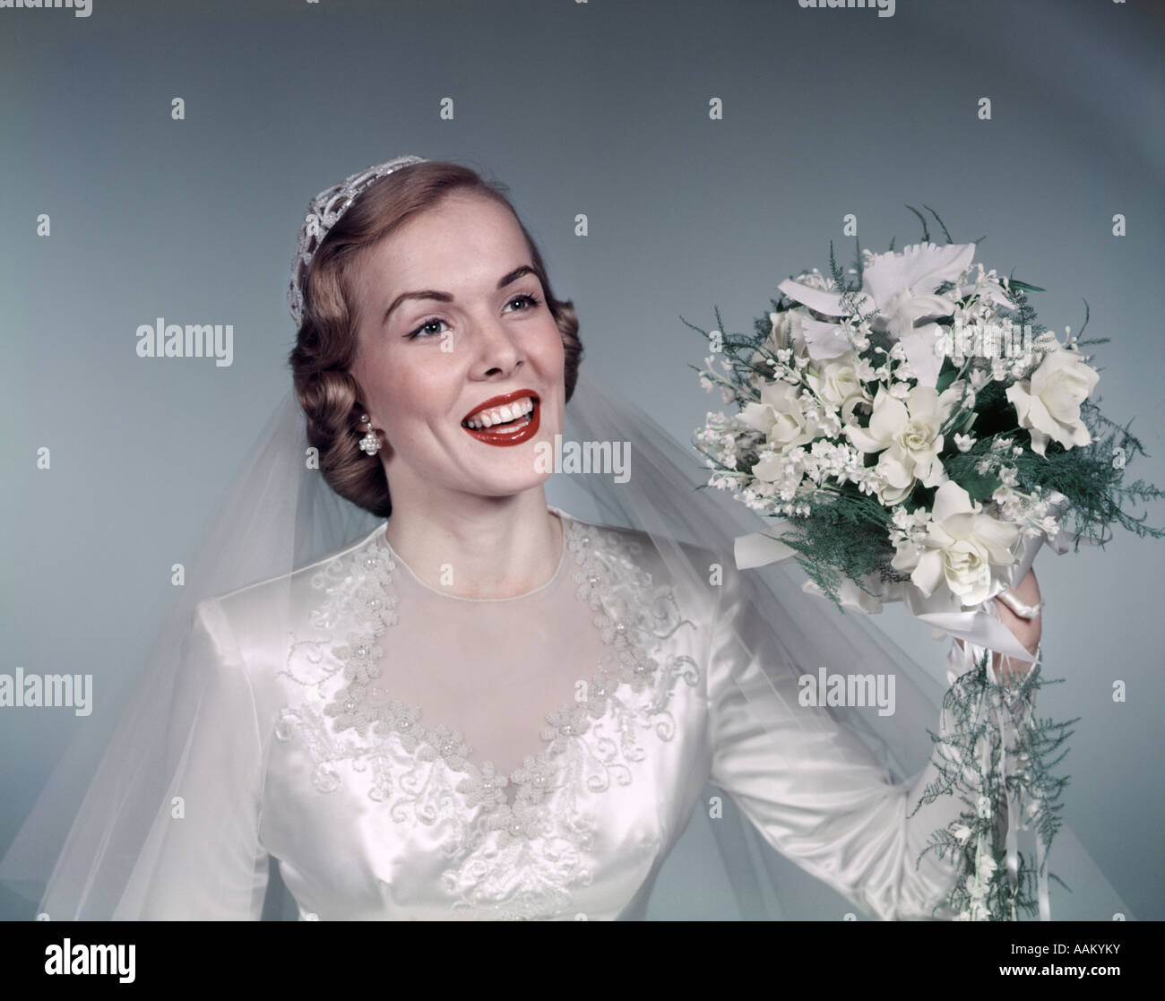 1950 BLONDE BRIDE SMILING HOLDING À PROPOS DE JETER DES FLEURS bouquet de mariée blanc dentelle robe voile FASHION Banque D'Images
