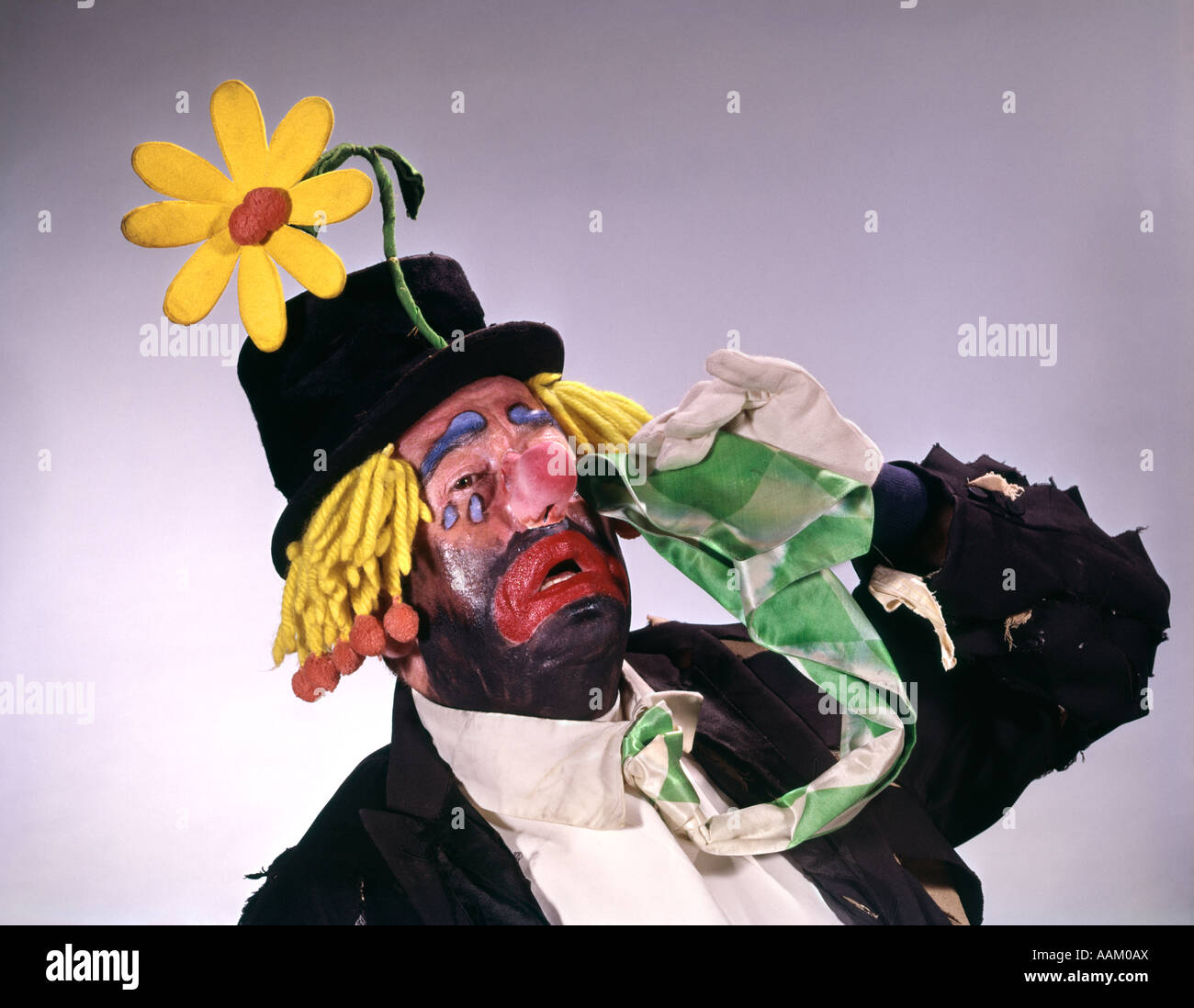 STYLE HOBO CLOWN PORTER HAUT CHAPEAU AVEC BIG DAISY PLEURER INTERPRÈTE FUNNY Banque D'Images