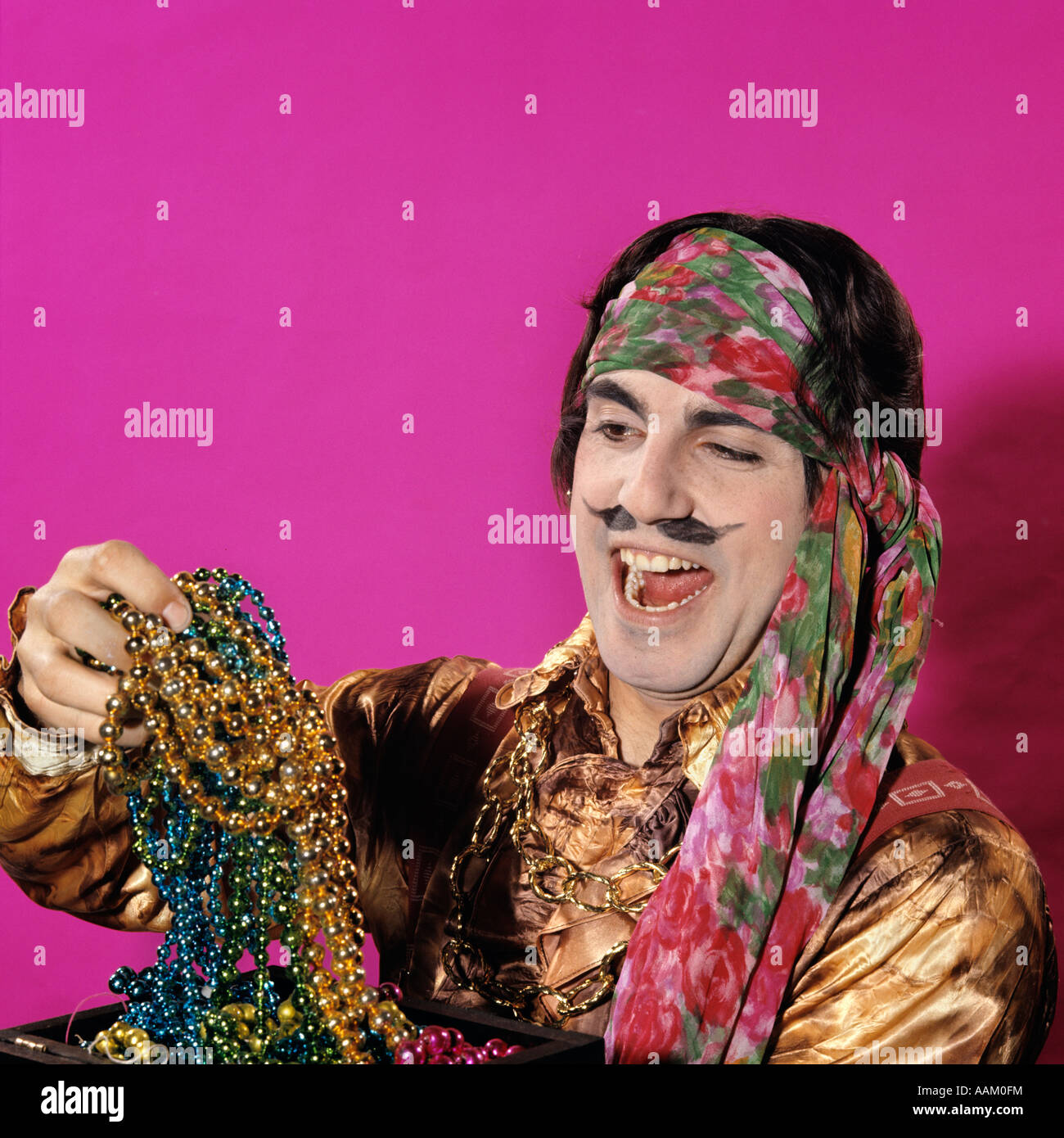Caractère des années 70, l'homme habillé en costume PIRATE EXPRESSION DROLE FAKE MOUSTACHE HOLDING DES TRÉSORS BIJOUX BOOTY RIRE Banque D'Images