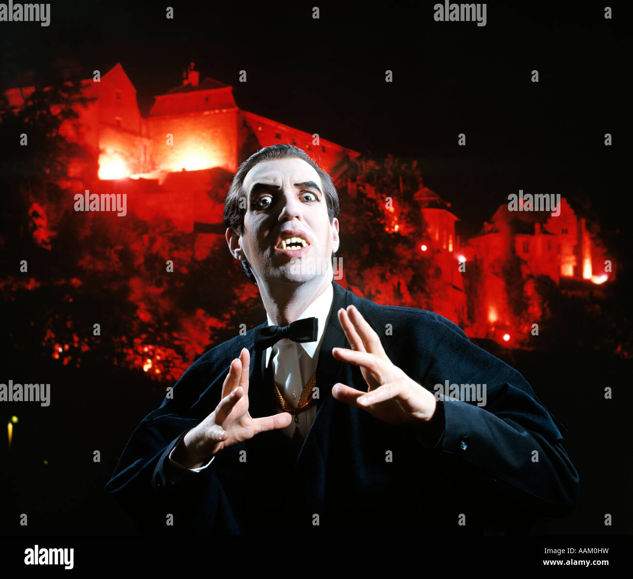 L'HOMME EN COSTUME ET maquillage de VAMPIRE GESTURING MENACINGLY CHÂTEAU BACKGROUND STUDIO SUPERSTITION FOLKLORE Banque D'Images