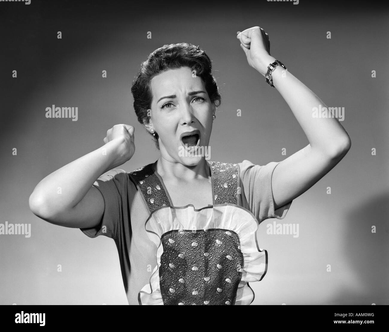 1950 FEMME EN TABLIER DENTELLE EDGE POINGS JUSQU'À L'AIR DE CRIER crier en colère contre la femme au foyer Banque D'Images