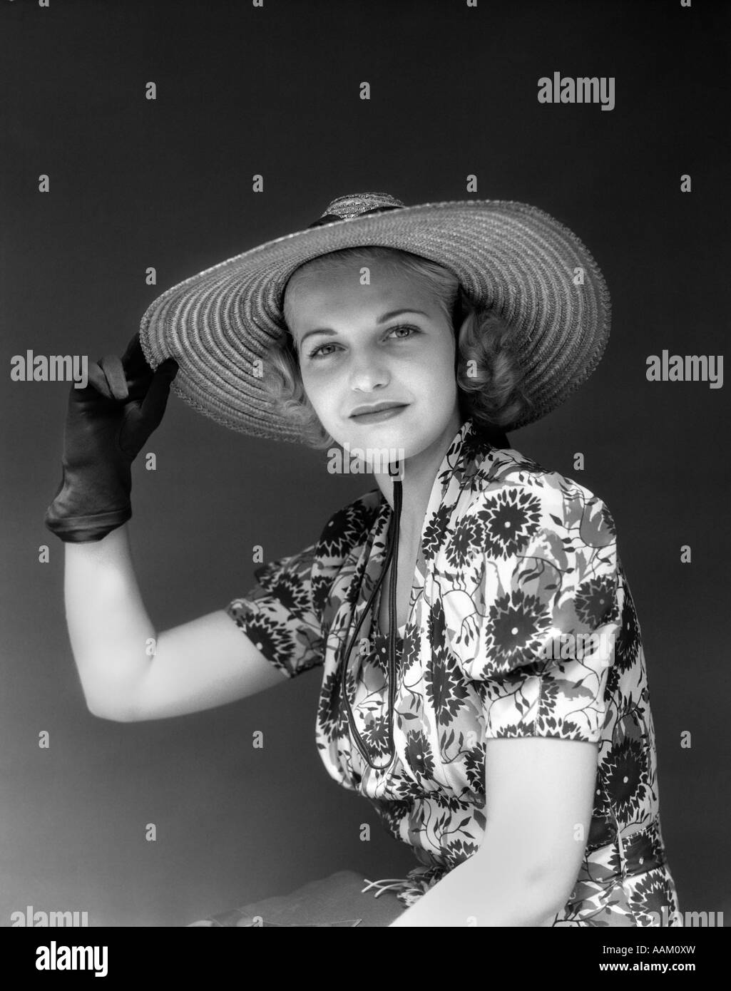 Années 1930 Années 1940 PORTRAIT Femme au chapeau de paille ROBE FLORAL  HAND HOLDING HAT PORTANT DES GANTS LOOKING AT CAMERA Photo Stock - Alamy