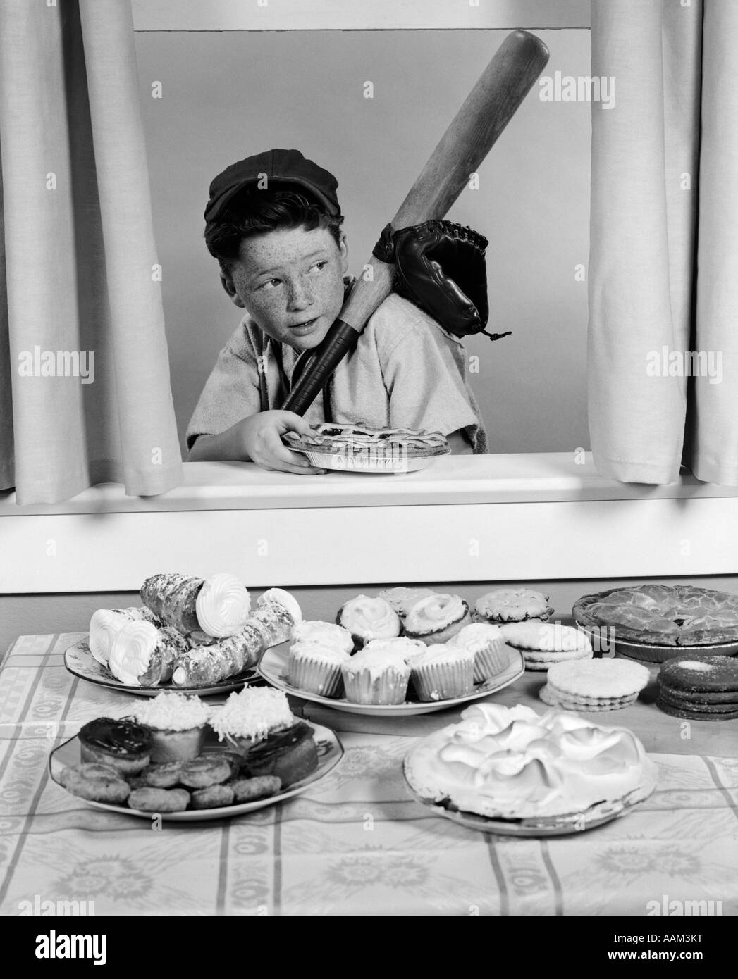 1950 garçon EN COSTUME BASEBALL BAT AVEC PIE furtivement par fenêtre ouverte Banque D'Images