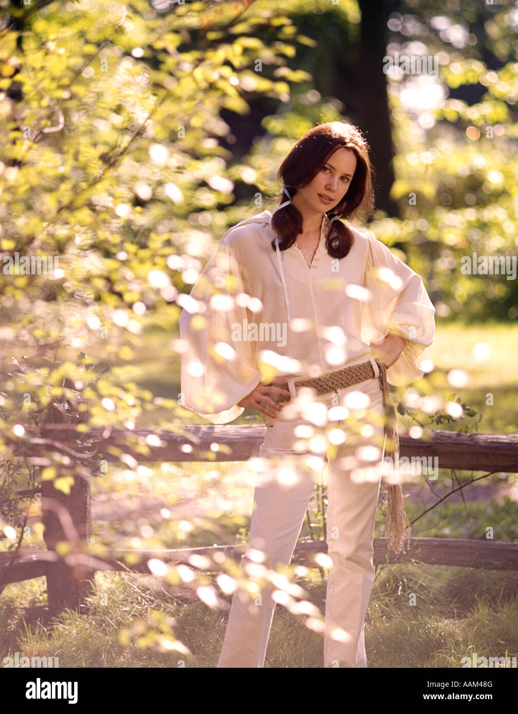 Des années 1970, JEUNE FEMME À L'EXTÉRIEUR BLANC DE PRINTEMPS TES JEANS CEINTURE MACRAMÉ chemisier blanc pur SHIRT FASHION Banque D'Images