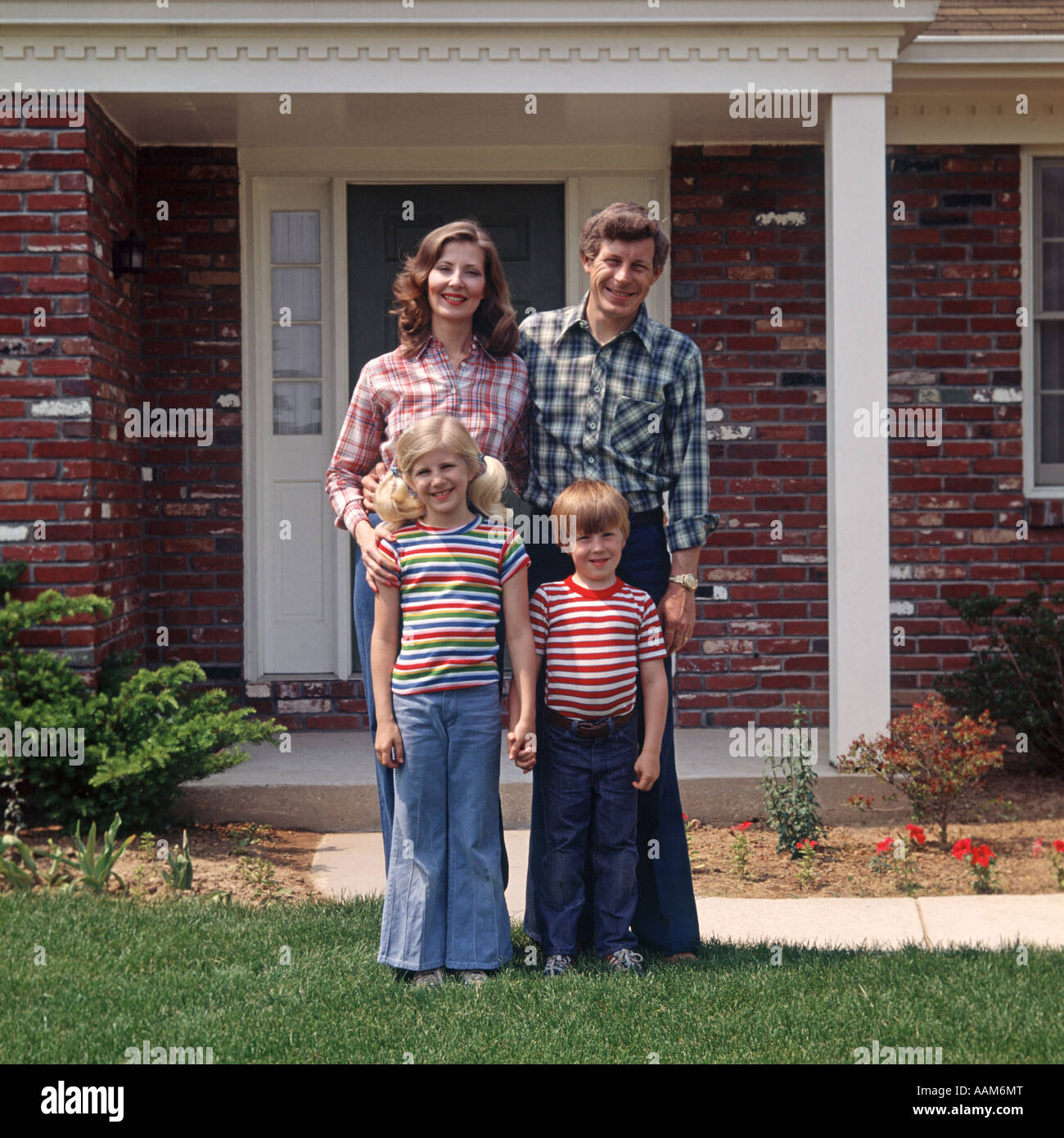 FAMILY POSING sur pelouse à l'extérieur chambre Banque D'Images