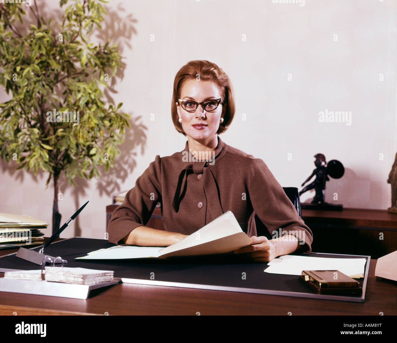 1960 WOMAN BUSINESS WOMAN SEATED 24 EXPRESSION GRAVE LUNETTES DOCUMENTS  SECRÉTAIRE DE DIRECTION Photo Stock - Alamy