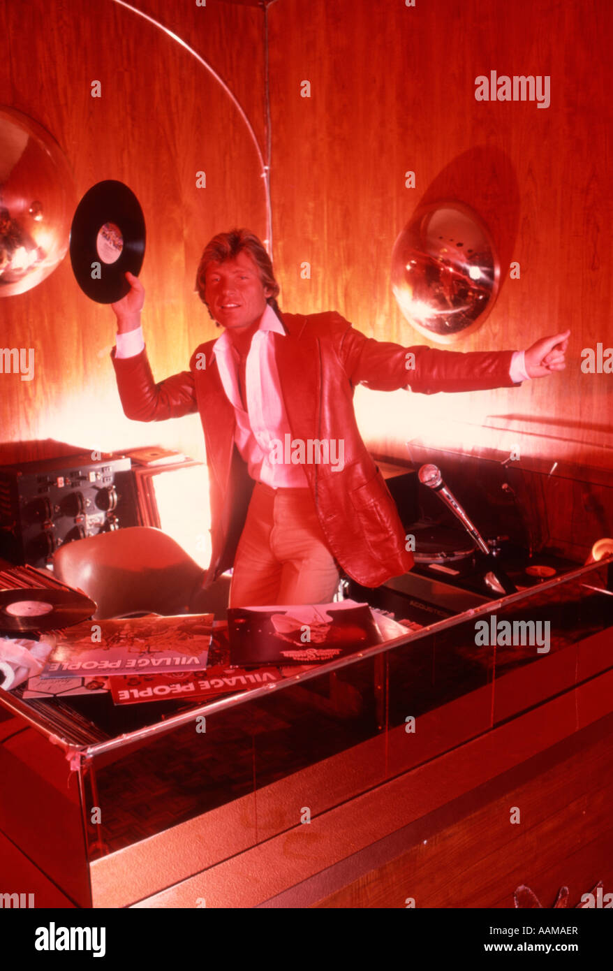 1970 disk jockey DJ EN STUDIO CABINE DE SON HOLDING UP 33 TOURS ET LA DANSE Banque D'Images