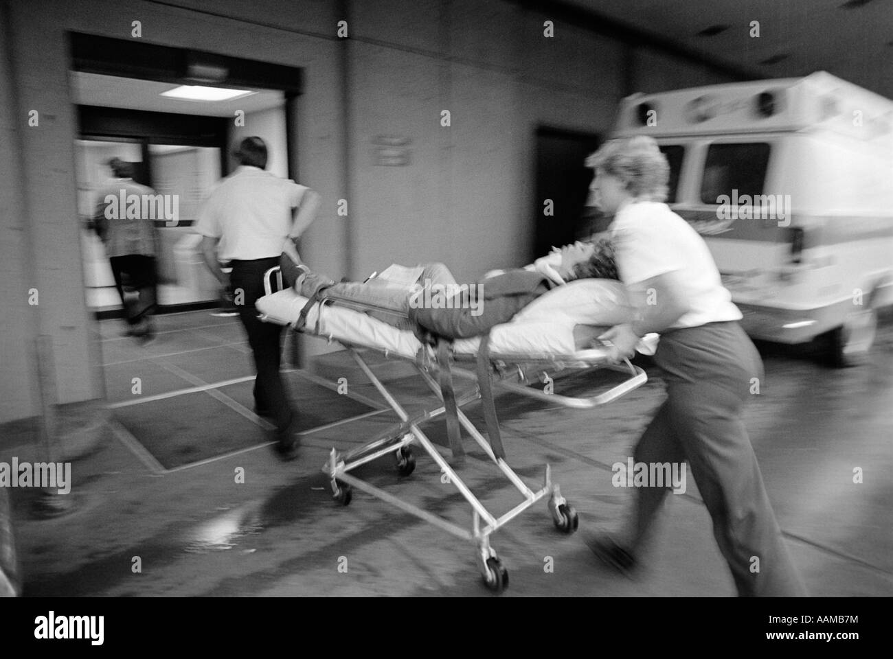 Des années 1980, l'équipe de l'EMT RUSHING PATIENT À l'hôpital sur une civière Banque D'Images