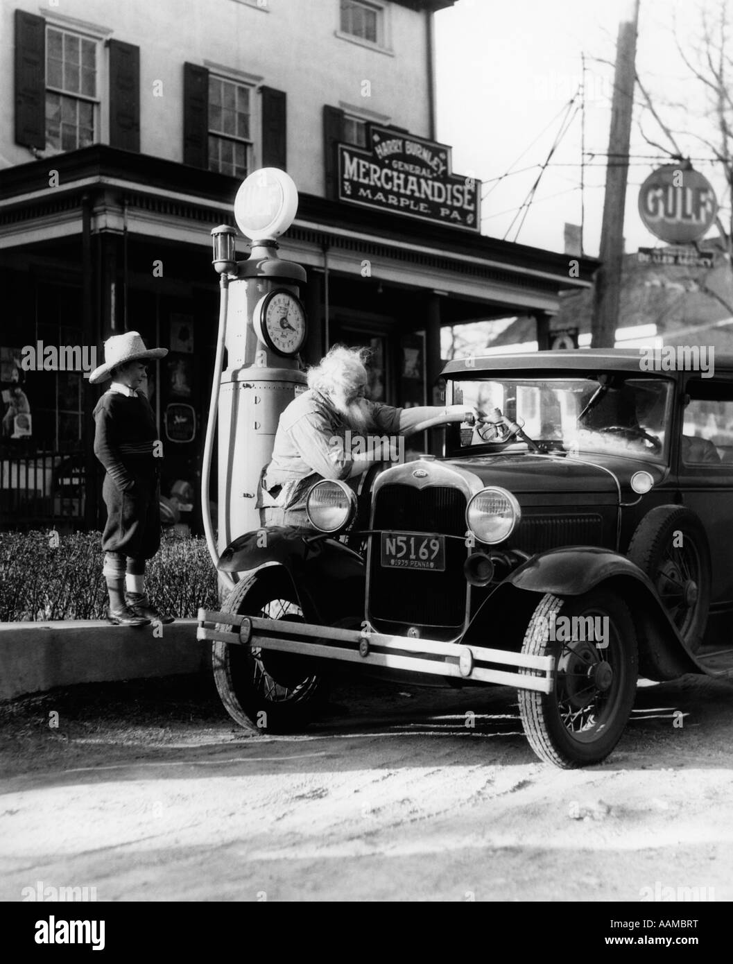 Grand-père âgé de la MISE À NIVEAU DE FORD VOITURE À L'AVANT DU MAGASIN GÉNÉRAL DE PENNSYLVANIE Avec petit-fils regardant des années 1930 Banque D'Images