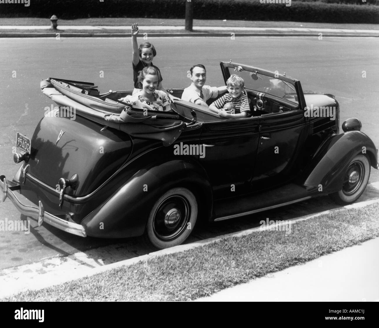 1940 FAMILLE DE QUATRE FORD V-8 CONVERTIBLE SEDAN SMILING AT CAMERA Banque D'Images