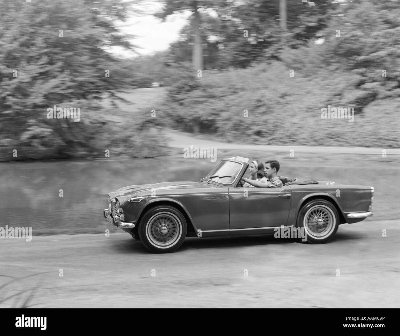 1960 COUPLE roulant en voiture sport décapotable Banque D'Images