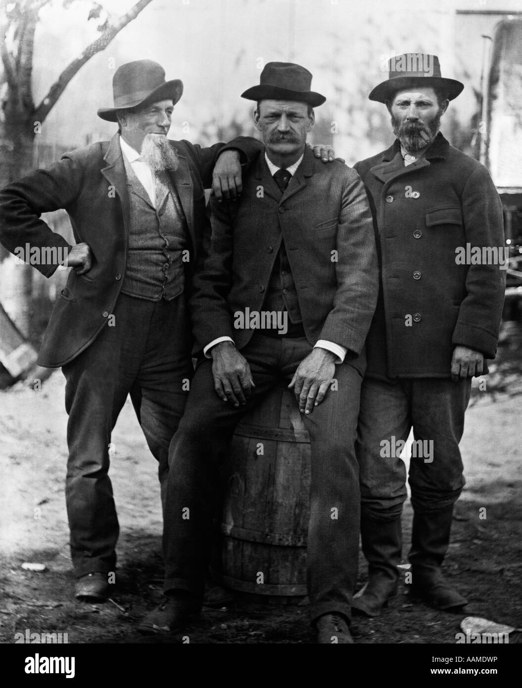 1890 DÉBUT DU SIÈCLE GROUPE DE TROIS HOMMES AVEC barbe ou moustache porter  un chapeau l'un assis sur le fût Photo Stock - Alamy