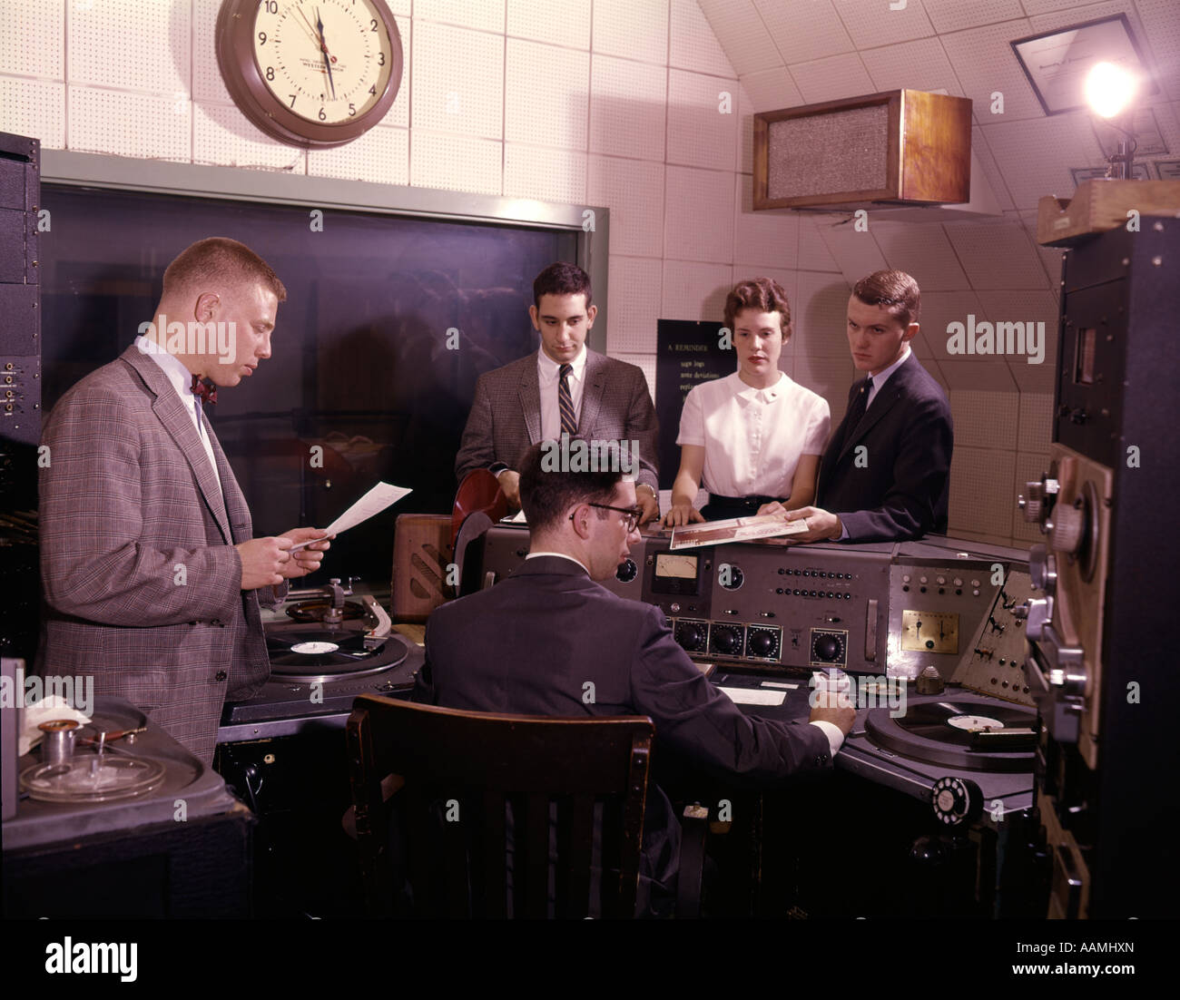 1960 GROUPE DE 5 PERSONNES DANS LA SALLE DE COMMANDE DE LA STATION DE RADIO disk jockey DJ TURNTABLES COMMUNICATIONS MÉDIAS DE RADIODIFFUSION Banque D'Images