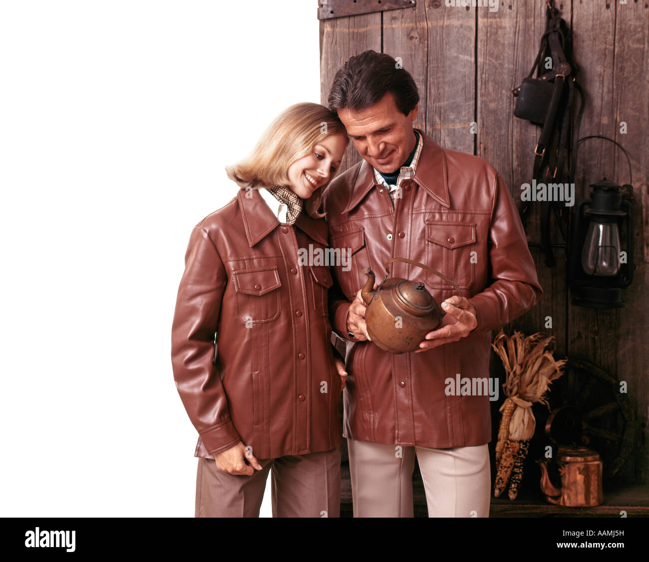 1970 1970 COUPLE HOMME FEMME portant des vestes de cuir à la recherche d'ANTIQUITÉS À LA MODE RÉTRO VÊTEMENTS POT Banque D'Images