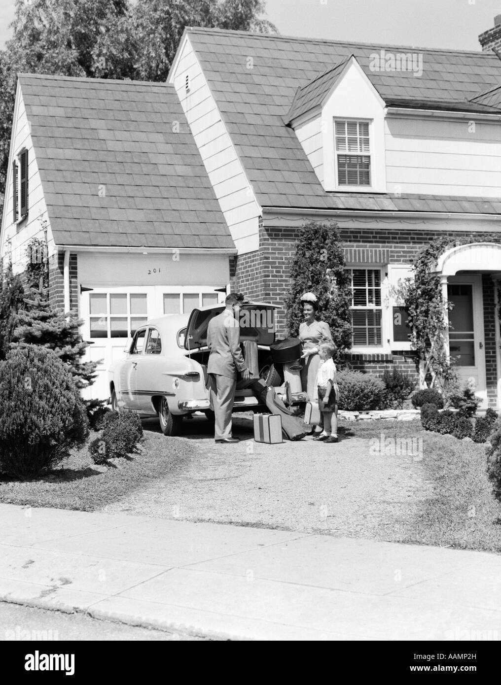 Années 1950 La famille de la mère père FILS EN FACE DE SUBURBAN HOUSE LOADING COFFRE DE VOITURE AVEC UNE ASSURANCE VOYAGE VALISE SAC DE GOLF LOCATIONS Banque D'Images