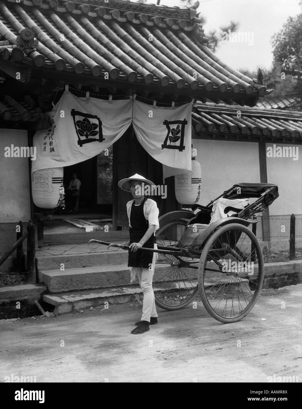 1930 HOMME JAPONAIS pousse-pousse RIKSCHA JINRIKSHA TRAVAILLEUR TIRANT DEBOUT DEVANT TEMPLE À KOBE AU JAPON Banque D'Images