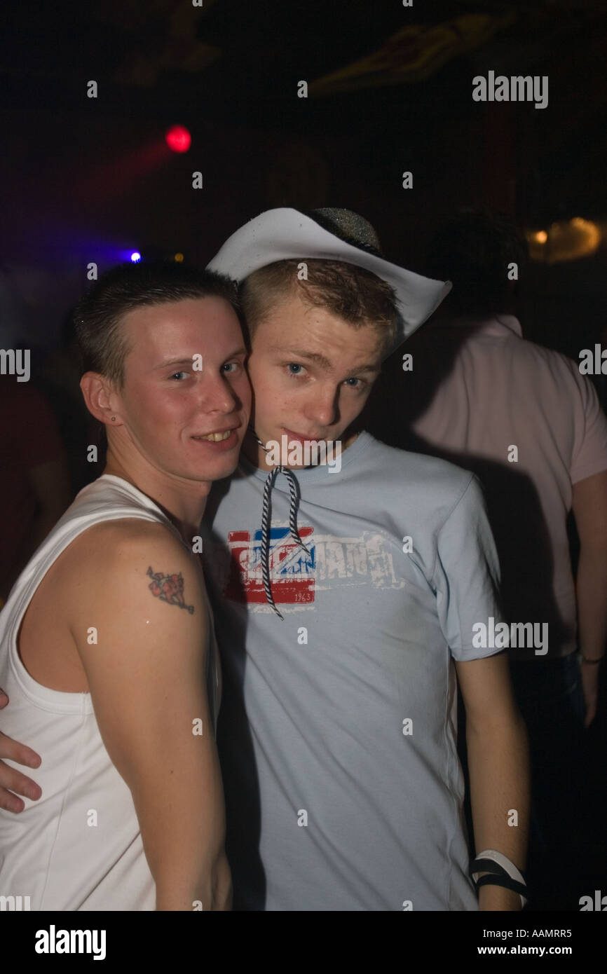 Jeune homme couple gay afficher leur affection en public dans une discothèque Banque D'Images