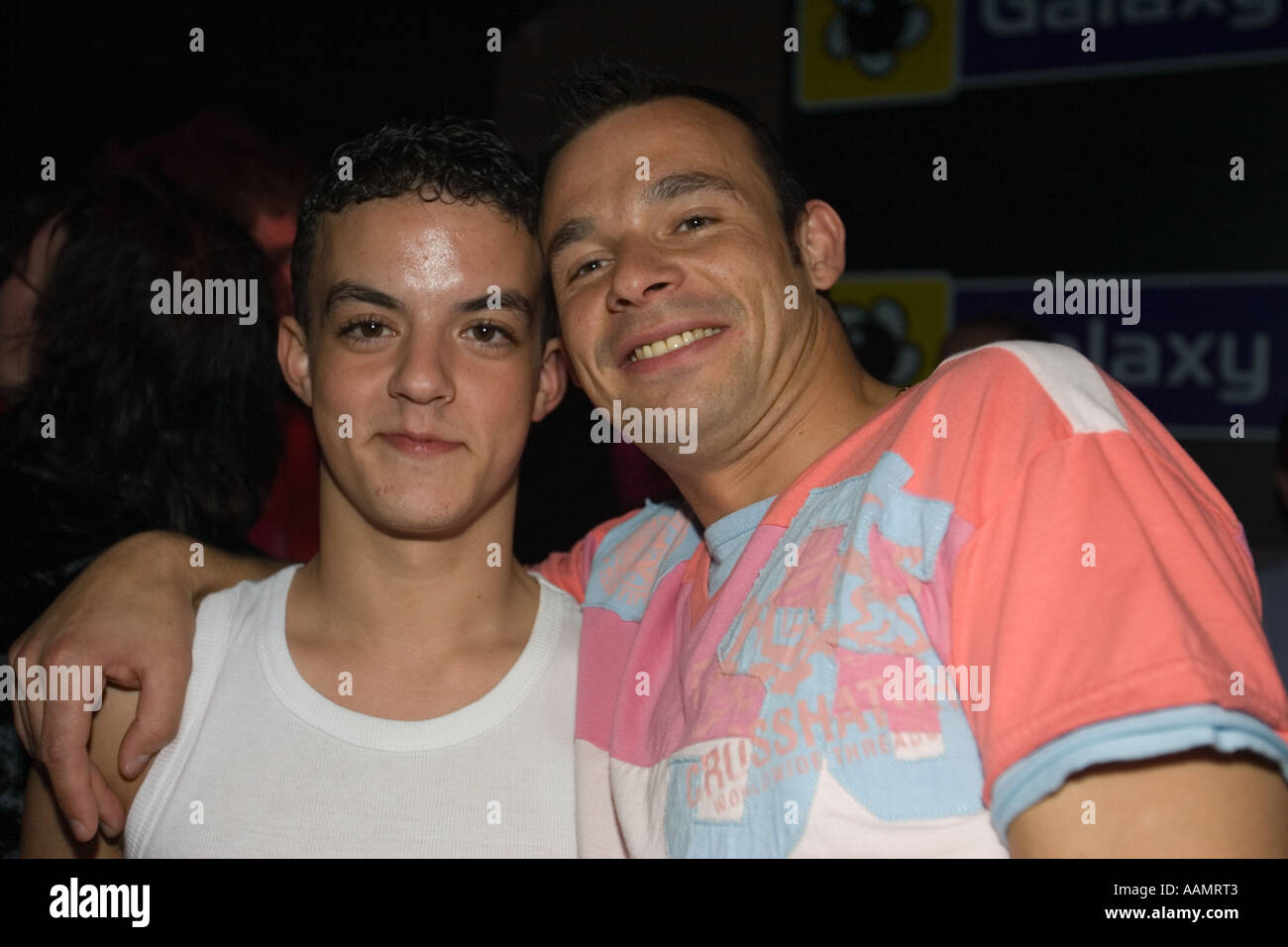 Jeune homme couple gay afficher d'affection en public dans une discothèque Banque D'Images