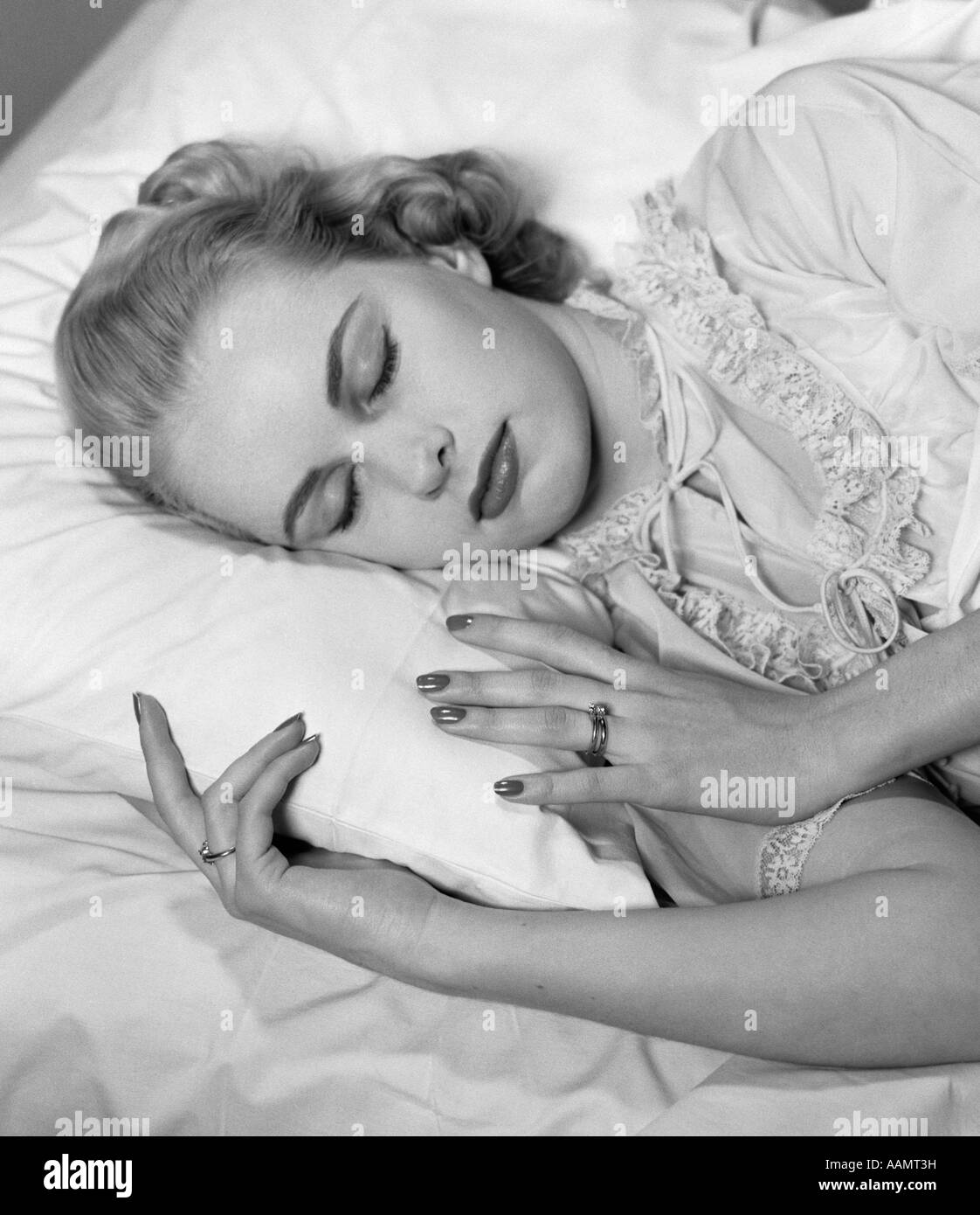 1950 BLONDE WOMAN ASLEEP IN BED OF BUILDING HÉRISSÉ D'USURE DU SOMMEIL Banque D'Images