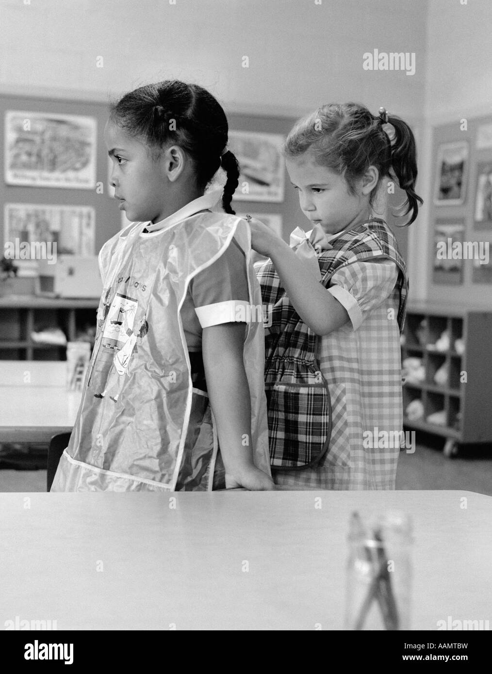 1960 LA FILLE DE L'ÉCOLE EN CLASSE SUR L'AMI DE LIAGE SMOCK TABLIER Banque D'Images