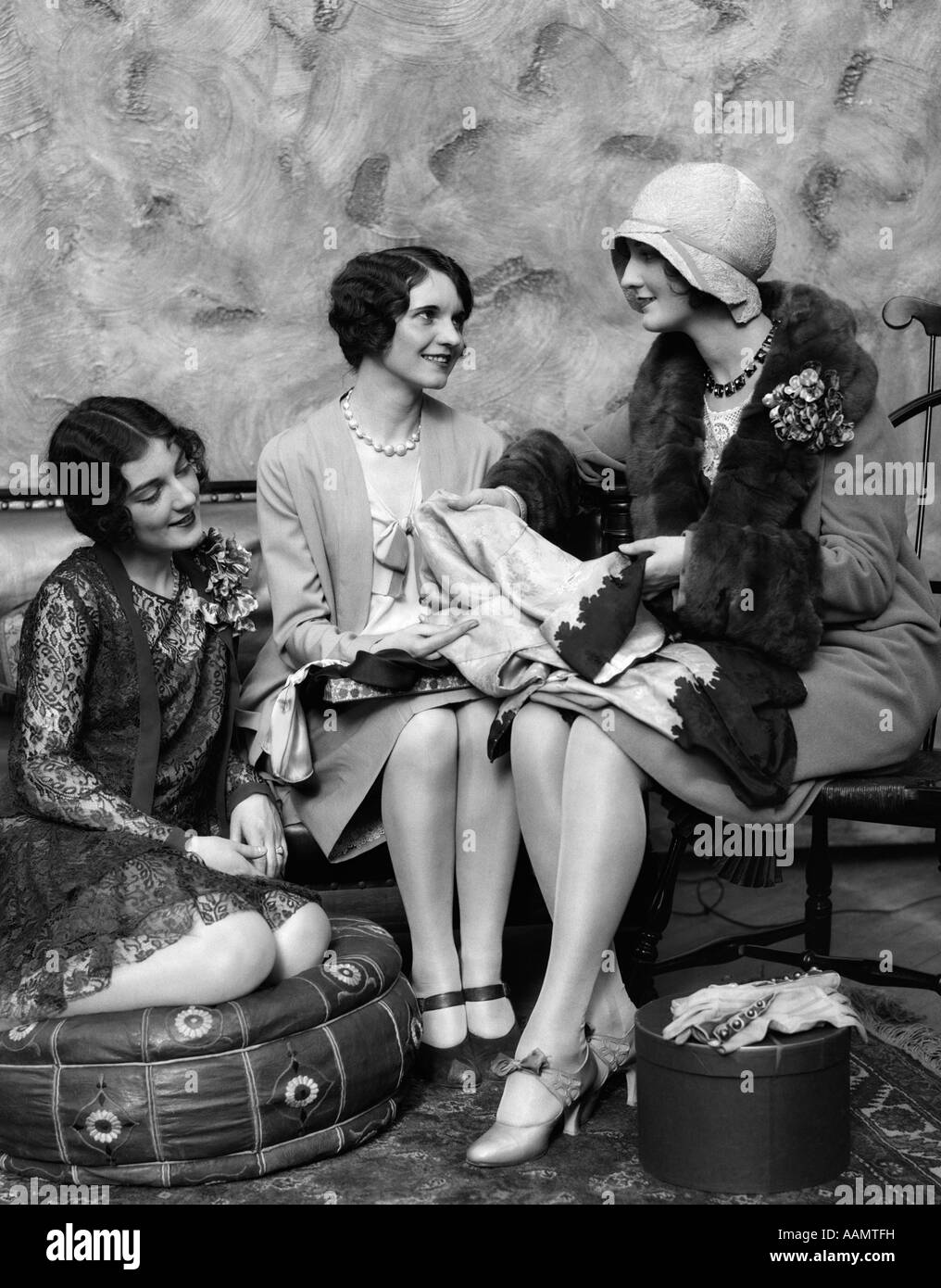 Années 1920 FEMME EN ROBE ET CHAPEAU DE RETOUR DE SHOPPING montrant les NOUVEAUX ACHATS À DEUX AMIS Banque D'Images