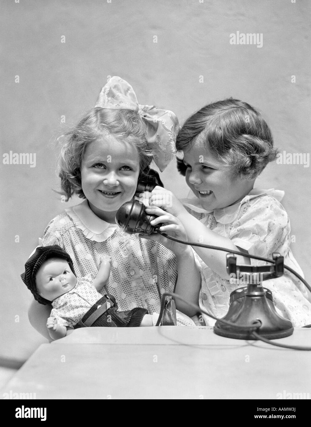 Années 1920 Années 1930 DEUX FILLES JOUANT AVEC TÉLÉPHONE Banque D'Images