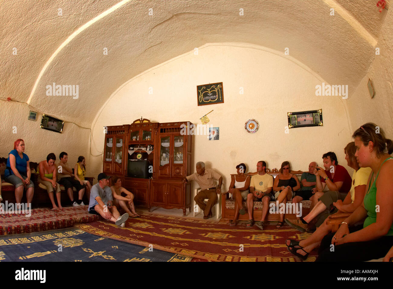 Guide et charge l'entraîneur des touristes britanniques l'intérieur de la grotte principale de la chambre souterraine troglodyte berbère en séjour à Marrakech Banque D'Images