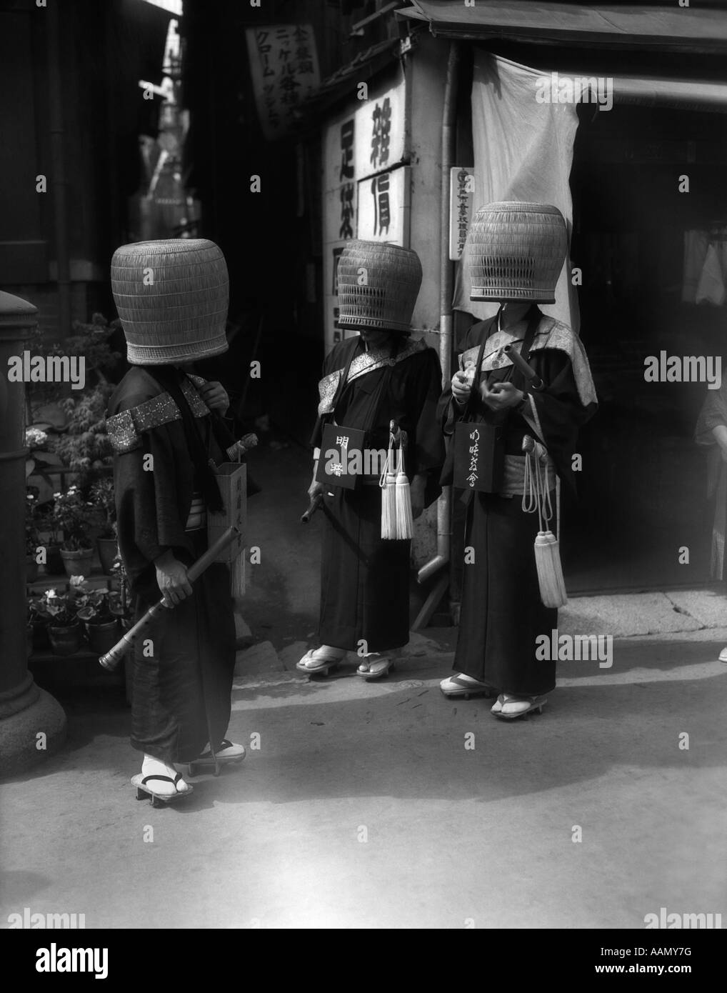 1930 MENDIANT JAPONAIS SAINTS HOMMES EN FACE DE TEMPLE RELIGIEUX portant des paniers plus généraux de la société secrète cachée AU JAPON Banque D'Images