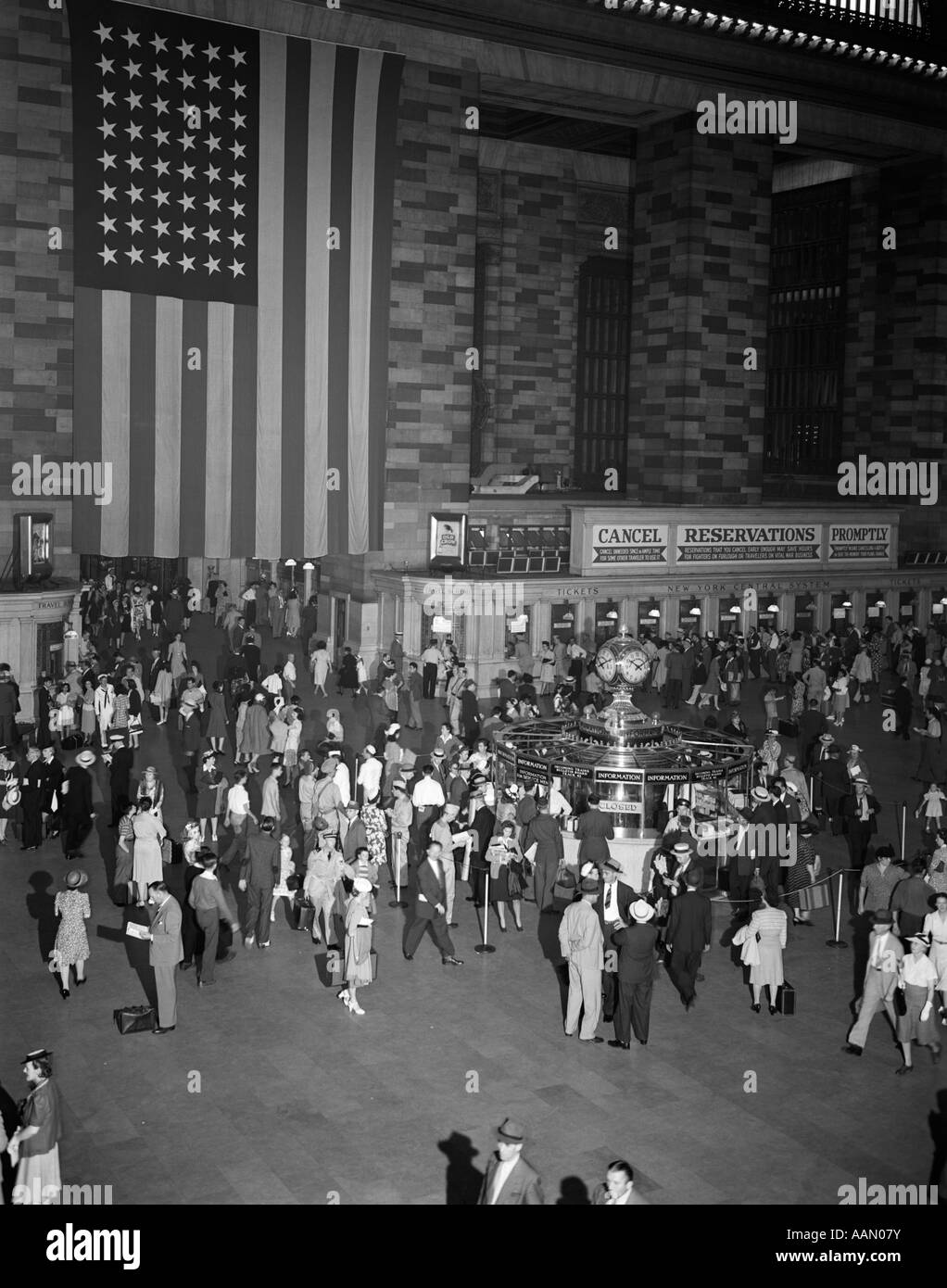 1940 Foule GRAND CENTRAL STATION grand drapeau américain accroché au mur INFORMATIONS WINDOWS TICKET BOOTH voyage Voyageurs Banque D'Images