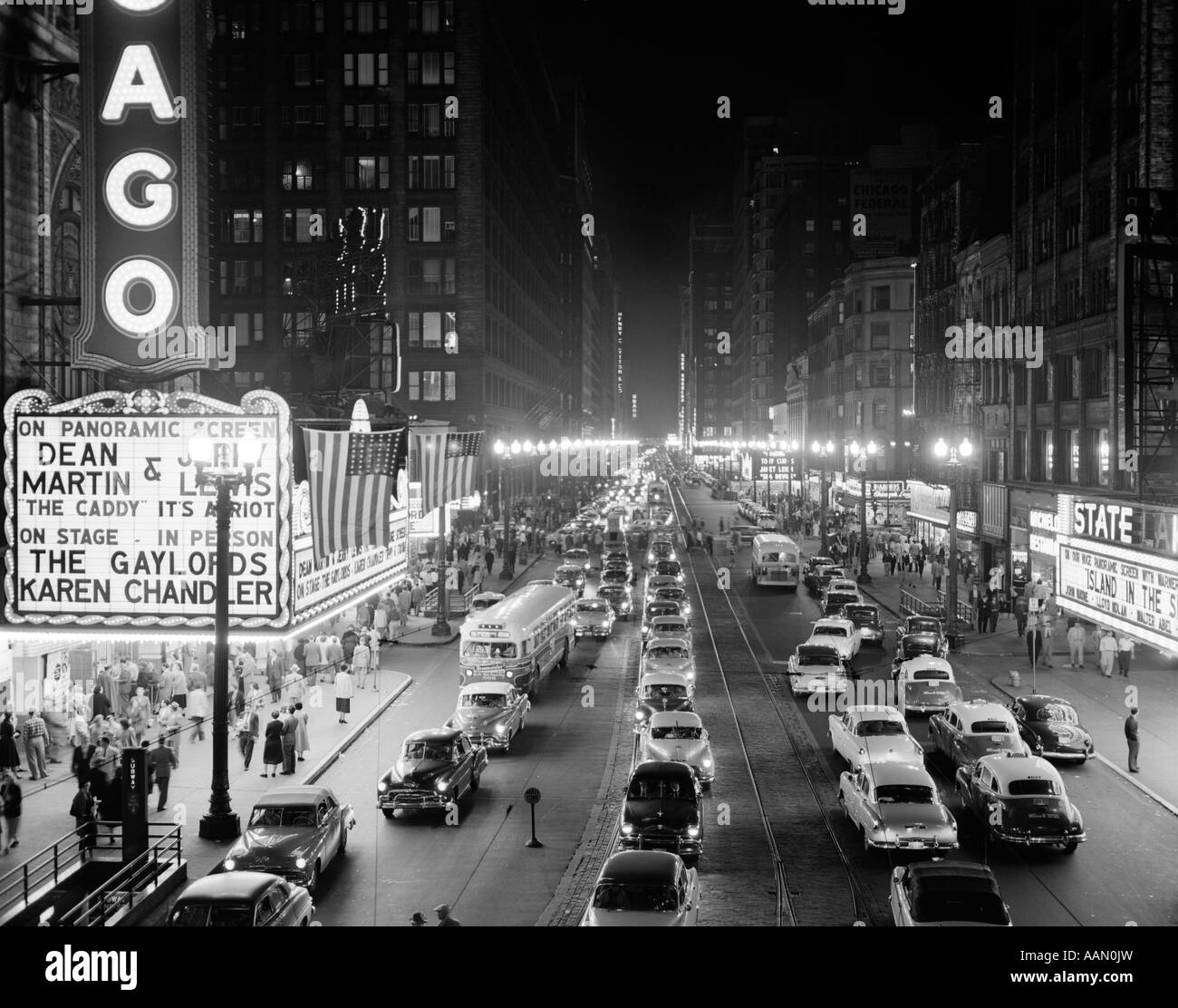 Années 50, 1953 SCÈNE DE NUIT DE CHICAGO STATE STREET AVEC LE TRAFIC ET LES PIÉTONS AVEC CHAPITEAU FILM SUR LES TROTTOIRS Banque D'Images