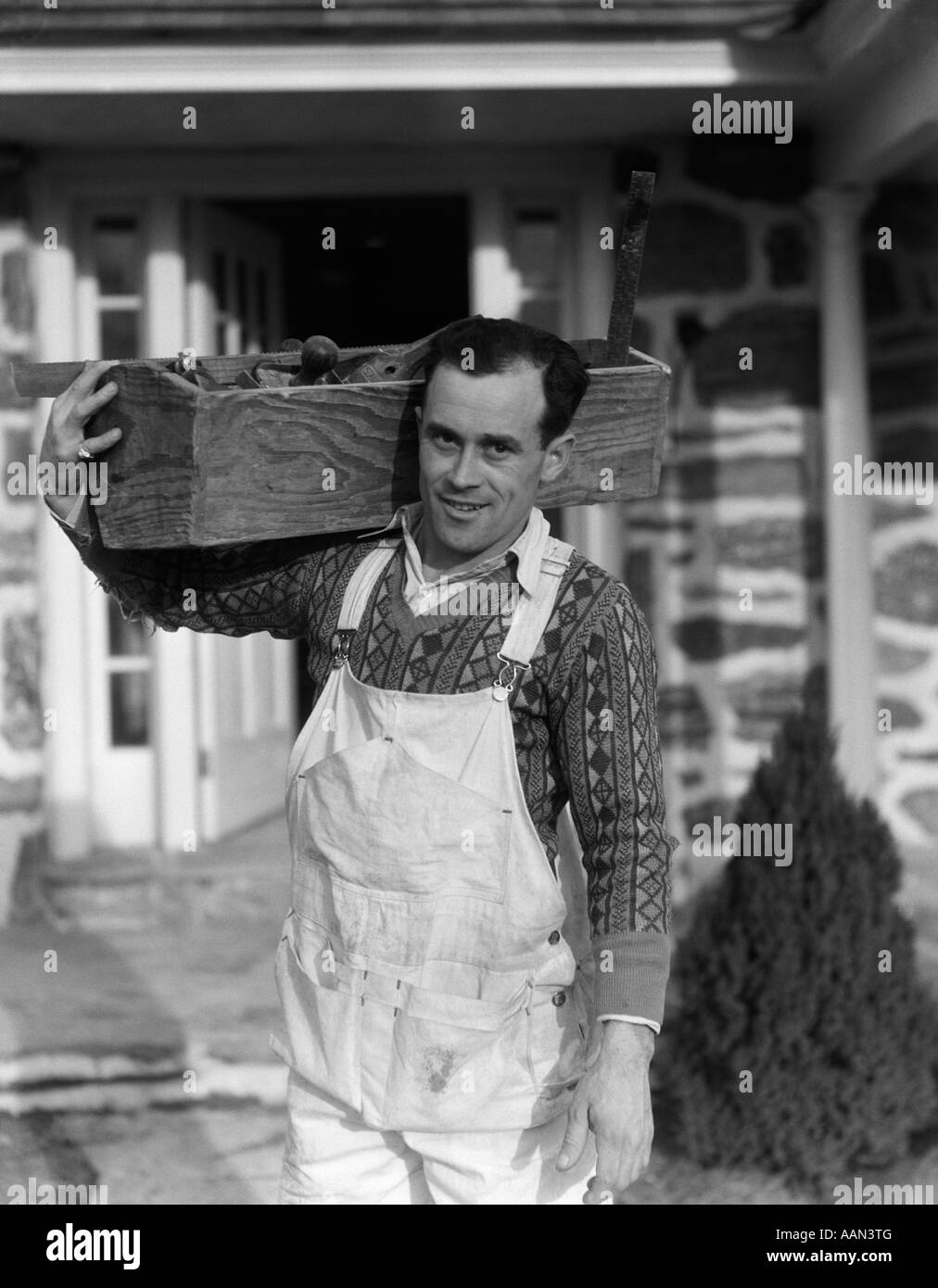 Années 1930 Années 1940 CARPENTER RÉALISATION BOÎTE À OUTILS SUR L'ÉPAULE  portant des bretelles SMILING AT CAMERA Photo Stock - Alamy