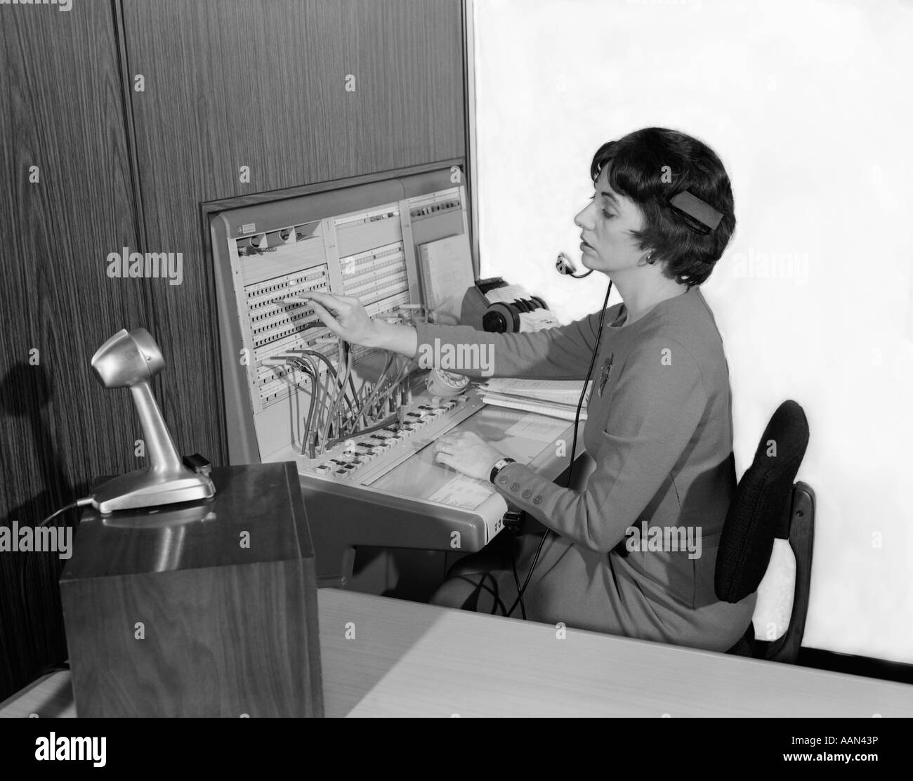 1960 FEMME AU BUREAU TÉLÉPHONE STANDARDISTE portant transfert de l'appel casque microphone answering service de Réceptionniste Banque D'Images