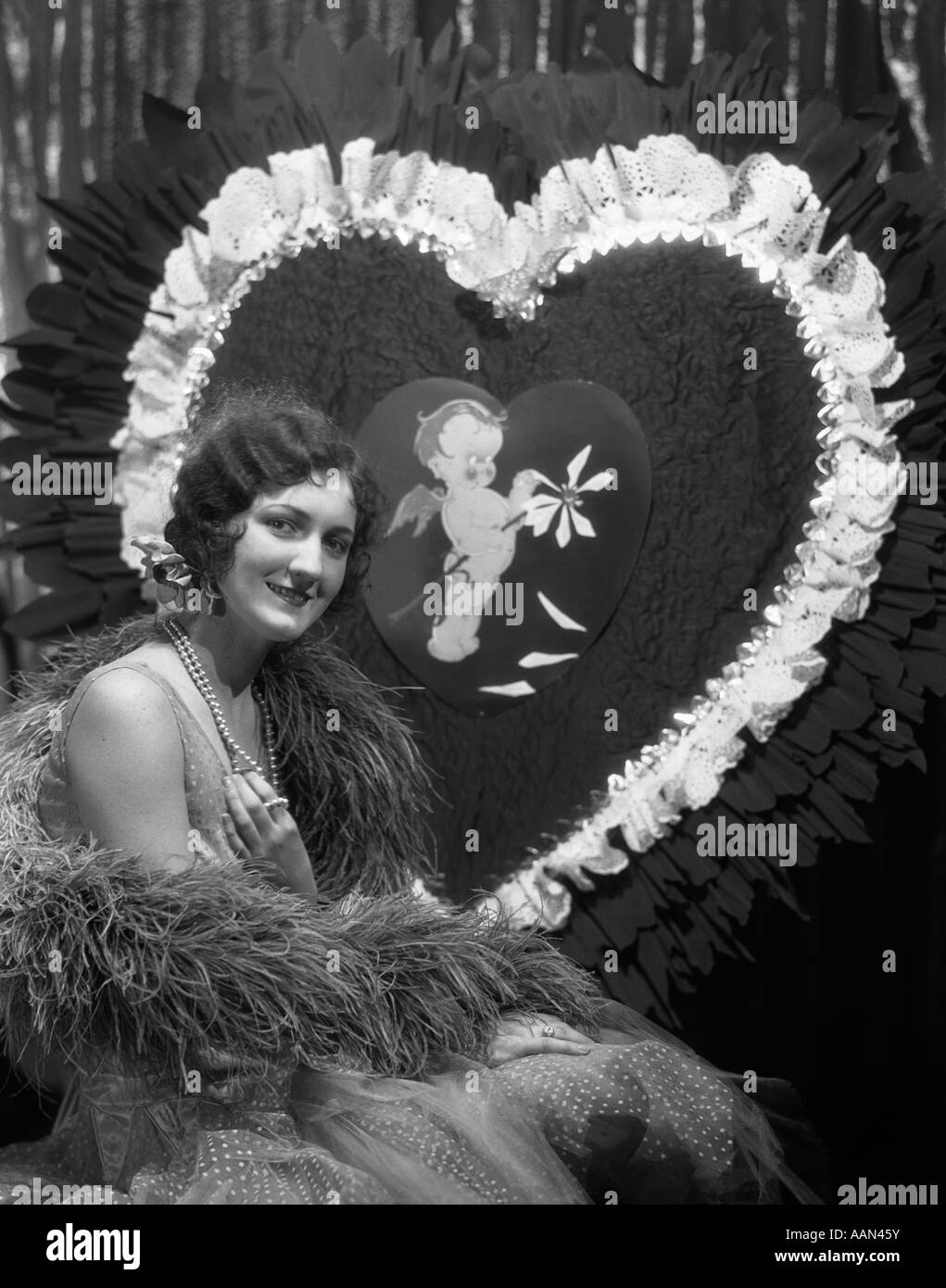 Années 1920 Années 1930 SMILING YOUNG WOMAN LOOKING AT CAMERA DOIGT CHEVEUX COLLIERS DE PERLES D'ONDE VALENTINE GÉANT Banque D'Images