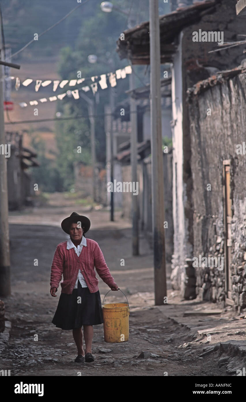 Femme péruvienne portant un seau d'eau dans une rue étroite Chavin de Huantar nord du Pérou en Amérique du Sud Banque D'Images