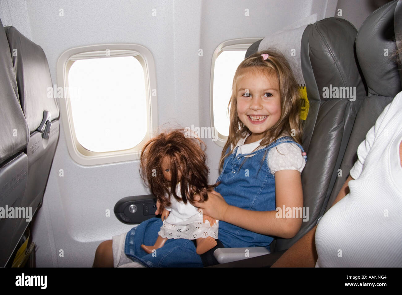 Little girl with doll in airplane Banque D'Images