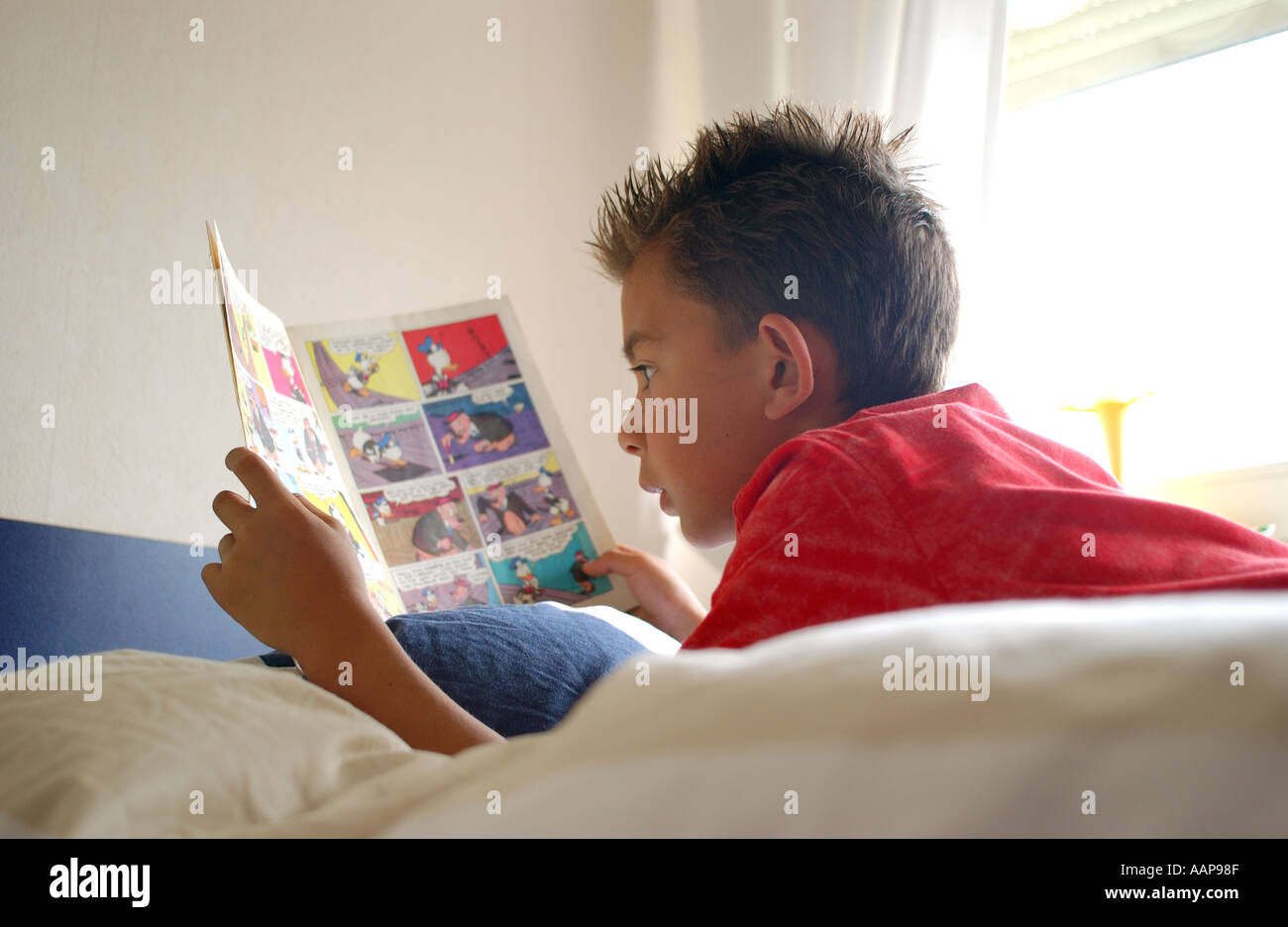 Boy reading comic book Banque D'Images