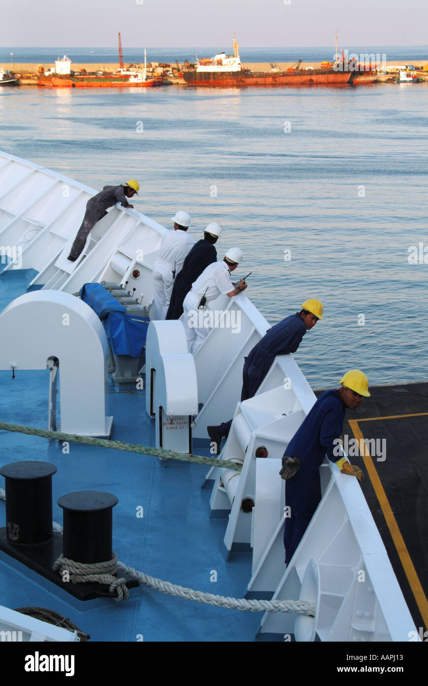 Les officiers et l'équipage on cruise ship penché au-dessus de la proue à vérifier les préparatifs de départ à quai Banque D'Images