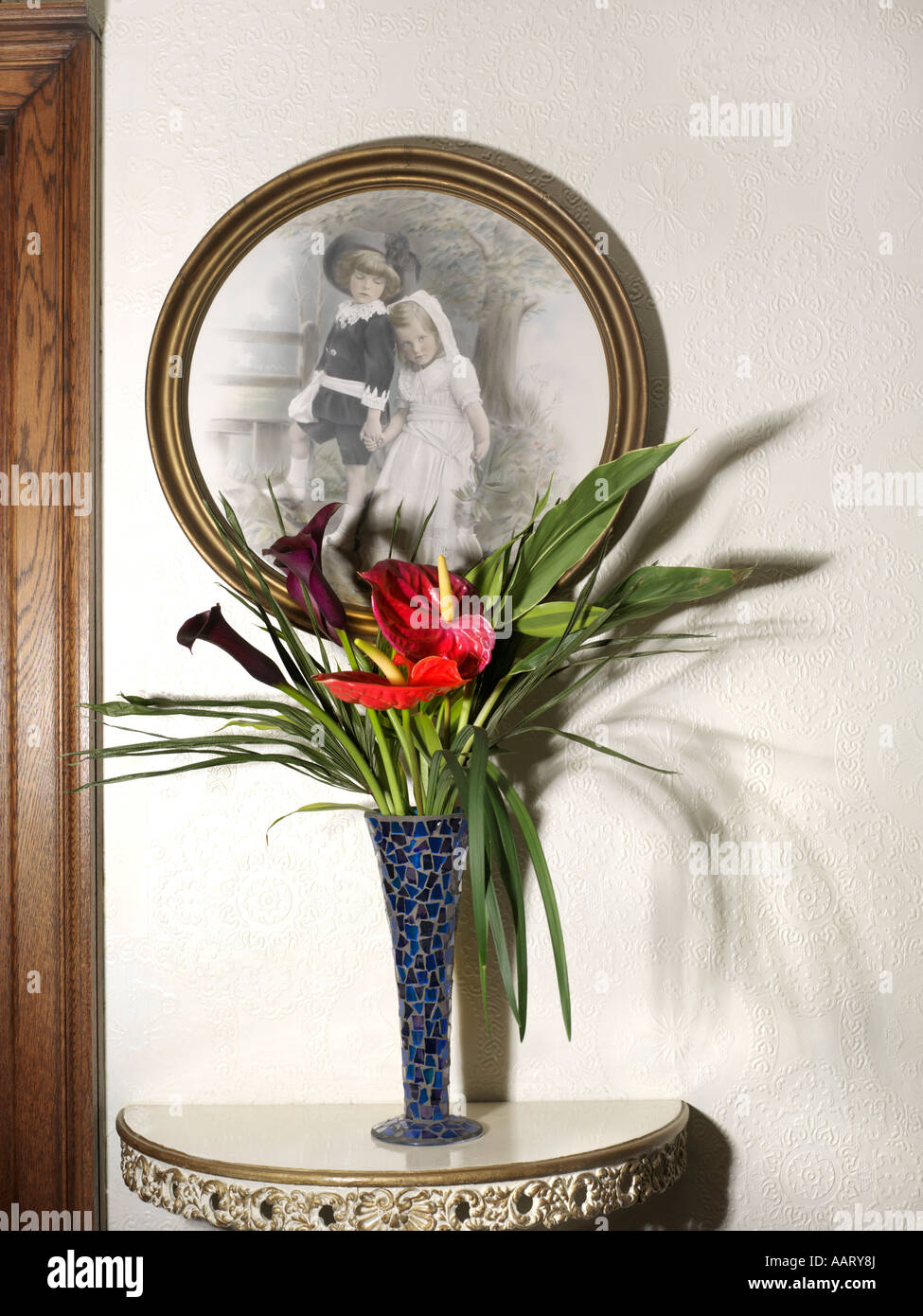 Vase en verre recyclé mosaïque bleu rouge avec Antirrhinums et début de photographie d'un frère et soeur Banque D'Images