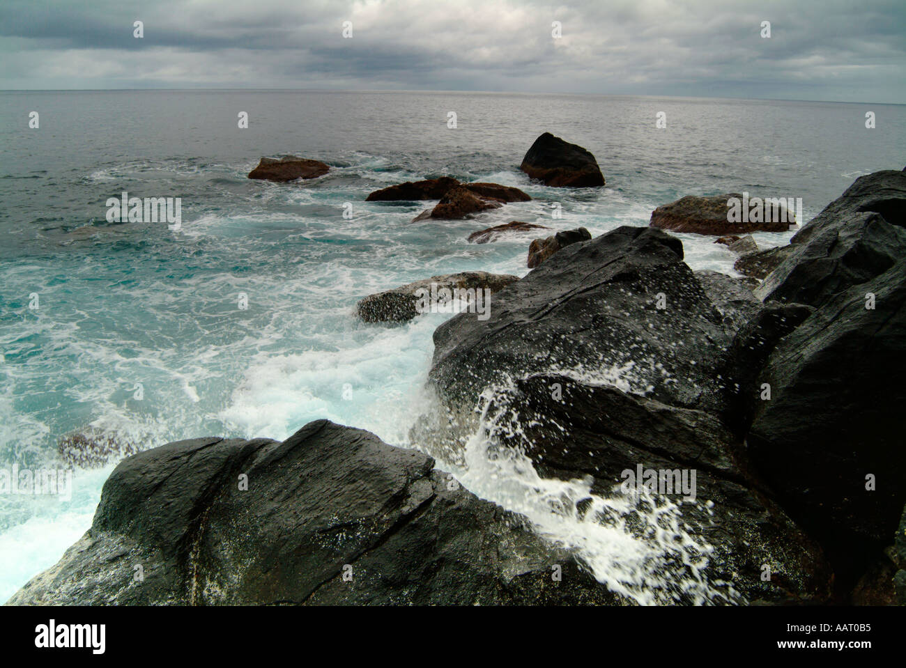 Briser les vagues sur une côte rocheuse Banque D'Images