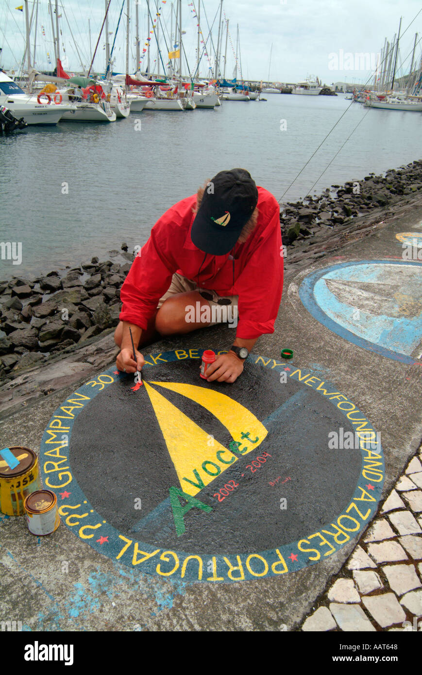 Un marin donne une représentation de son voyage et voilier sur la digue à Faial Horta aux Açores Banque D'Images