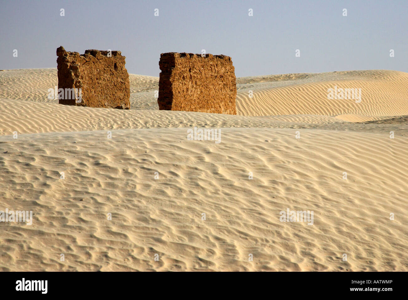 section de mur en ruines parmi les dunes de sable dans le sahara Désert à Douz Tunisie alors que les dunes de sable empiètent sur l'homme règlement de la désertification Banque D'Images