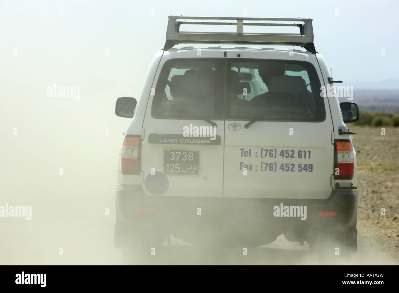 Véhicule hors route au volant de la poussière à vomir en terrain accidenté dans le désert tunisien Banque D'Images
